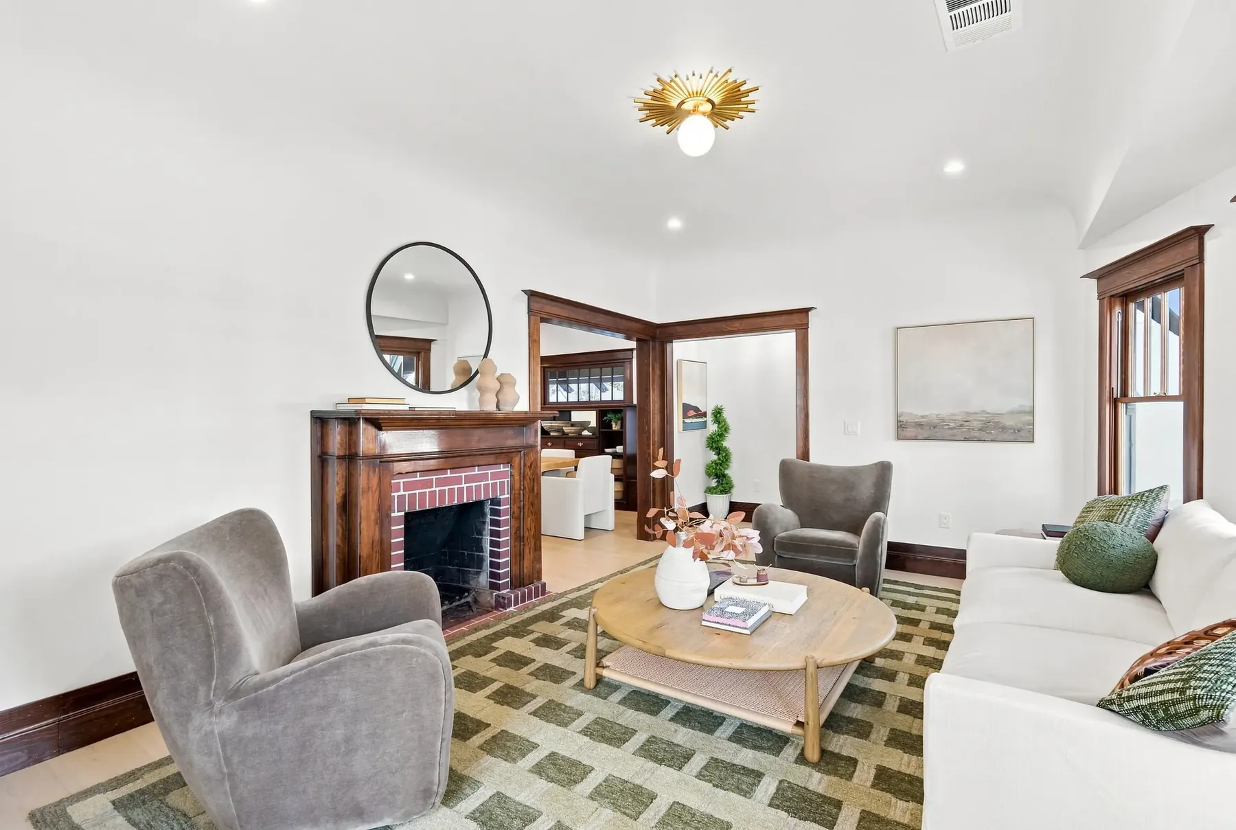 Living room toward the fireplace, with the original cased opening to the dining room in the background.