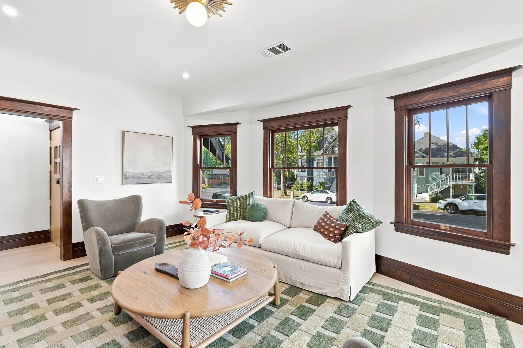 Living room toward the entry, showing the original trim profile against new white walls.